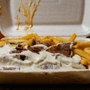 a takeout container with french fries and dip